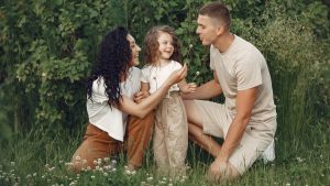 A joyful family enjoying time together in a lush green meadow, capturing love and bonding.