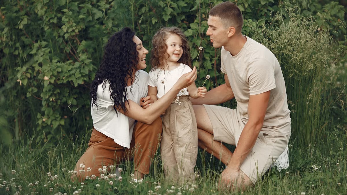 A joyful family enjoying time together in a lush green meadow, capturing love and bonding.