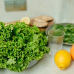 A vibrant display of fresh green lettuce and citrus fruits on a kitchen table.