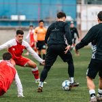 Young athletes in action during a soccer practice on a green field.