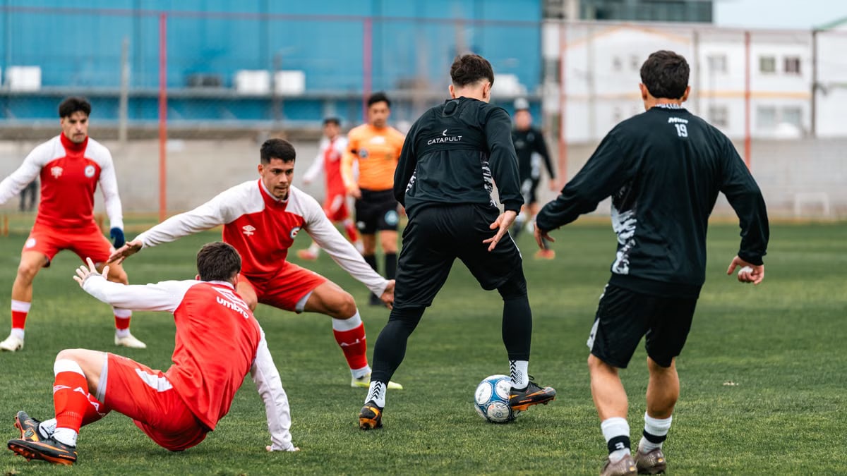 Young athletes in action during a soccer practice on a green field.